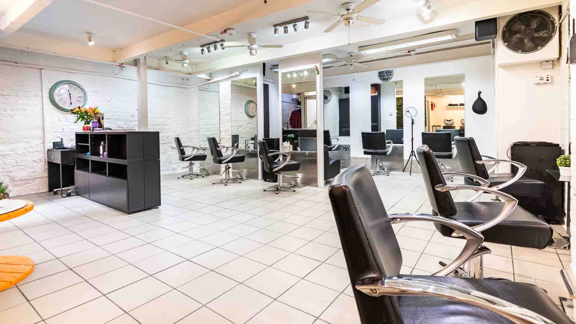 A salon interior featuring several chairs arranged around a central table.